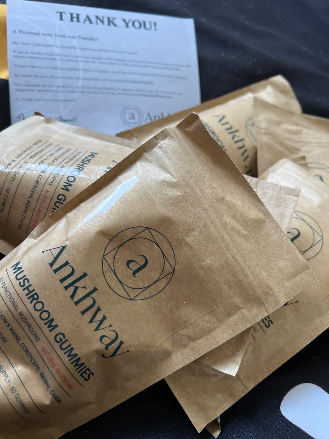 Bags of Ankhway mushroom gummies with a thank you note in the background.